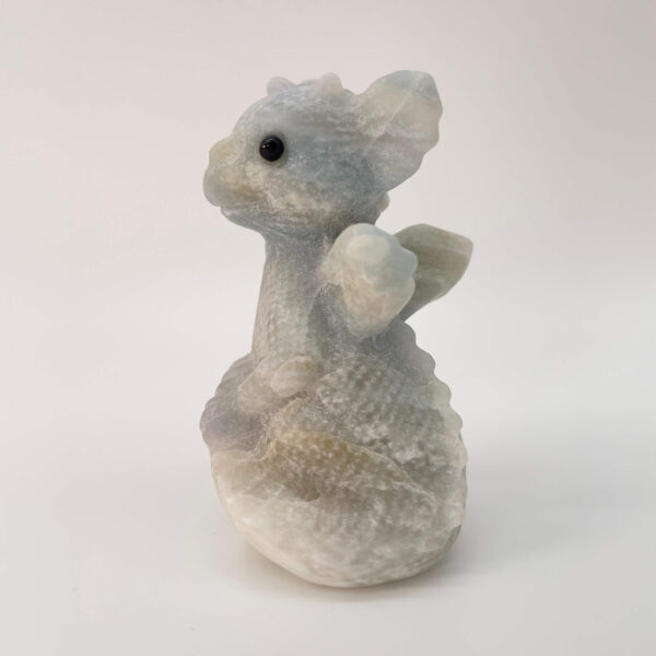 Blå Calsit krystal babydrage på hvid baggrund fra siden