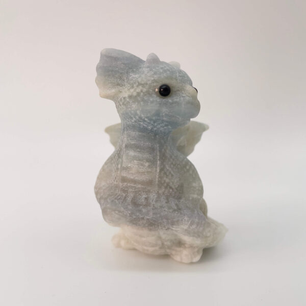 Blå Calsit krystal babydrage på hvid baggrund fra siden