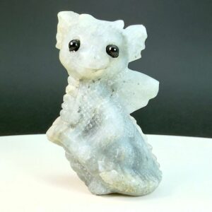 Labradorit krystal babydrage på hvid plade med sort baggrund