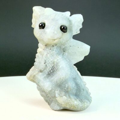 Labradorit krystal babydrage på hvid plade med sort baggrund