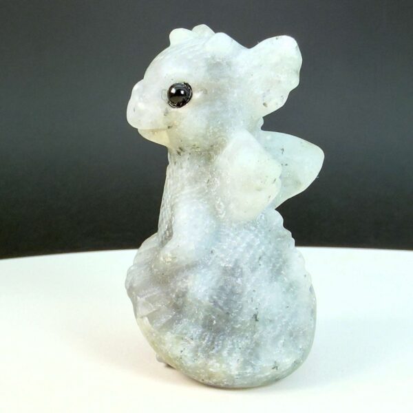 Labradorit krystal babydrage fra siden på hvid plade med sort baggrund