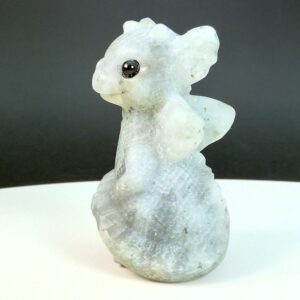 Labradorit krystal babydrage fra siden på hvid plade med sort baggrund