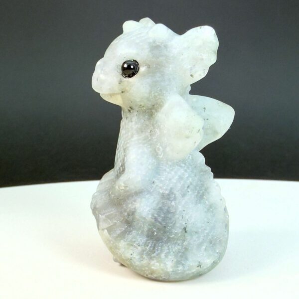 Labradorit krystal babydrage fra siden på hvid plade med sort baggrund