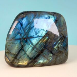 Labradorit krystal freeform støtte på hvid plade med blå baggrund