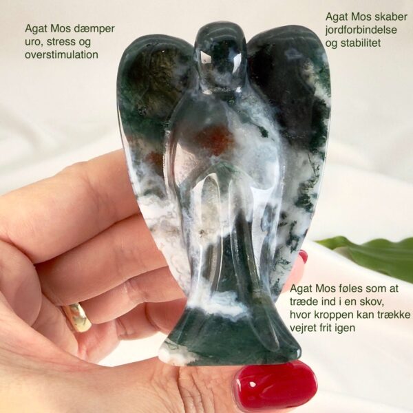 Agat mos krystal engel mellem fingre på hvid baggrund med grønt blad med tags