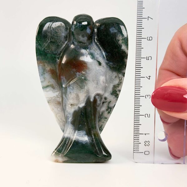 Agat mos krystal engel ved siden af lineal på hvid baggrund