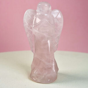 Rosakvarts krystal engel på hvid plade med lyserød baggrund