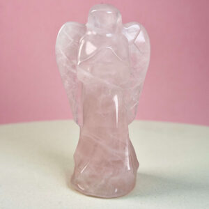 Rosakvarts krystal engel på hvid plade med lyserød baggrund