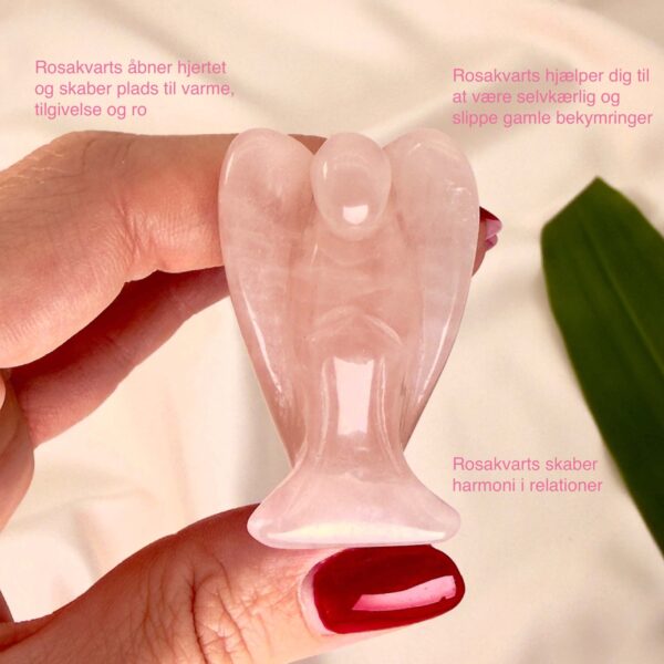 Rosakvarts 4 cmkrystal engel imellem fingre med hvid baggrund og grønt blad med tags