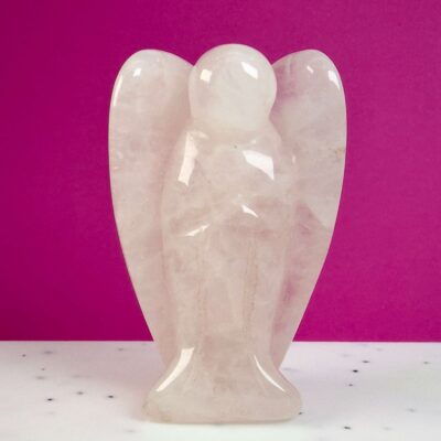 Rosakvarts krystal engel på hvid plade med lyserød baggrund