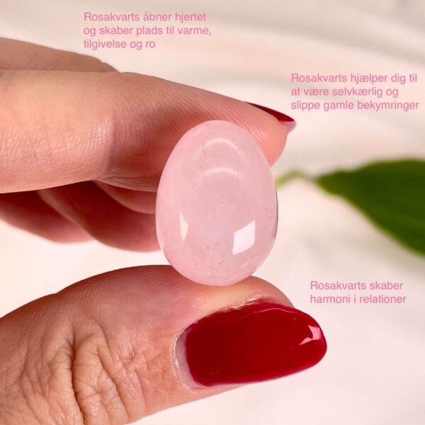 Rosakvarts mini æg mellem fingre med tags