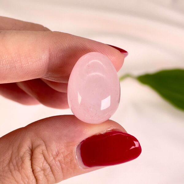 Rosakvarts mini æg mellem fingre