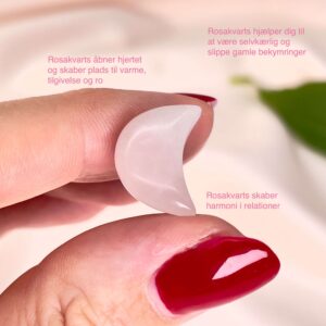 Rosakvarts mini måne imellem fingre med tags