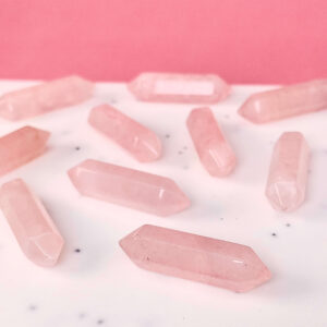 Rosakvarts mini spidser på skrå hvid plade med lyserød baggrund