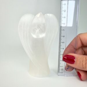 Selenit krystal engel ved siden af lineal på hvid baggrund