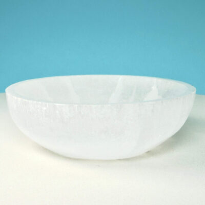 Selenit krystal 12 cm skål på hvid plade med blå baggrund