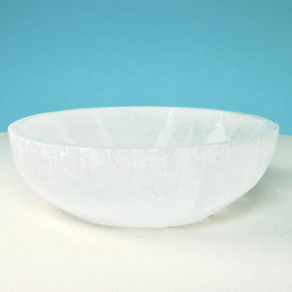 Selenit krystal 12 cm skål på hvid plade med blå baggrund