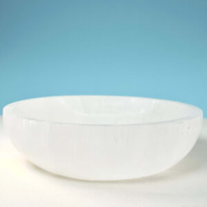 Selenit krystal 14 cm skål på hvid plade med blå baggrund