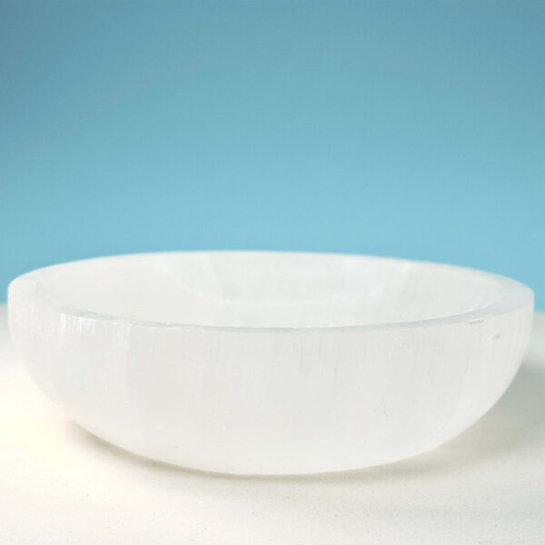 Selenit krystal 14 cm skål på hvid plade med blå baggrund