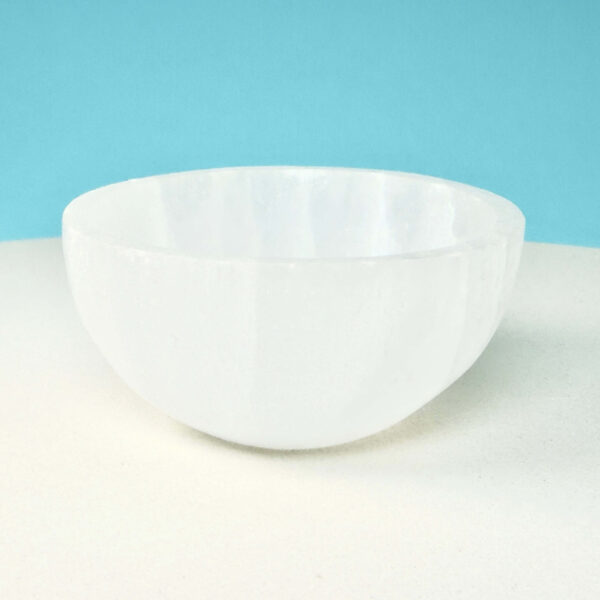 Selenit krystal 6,5 cm skål på hvid plade med blå baggrund