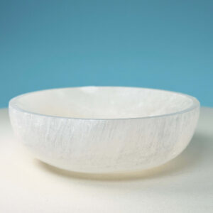 Selenit krystal 9,5 cm skål på hvid plade med blå baggrund