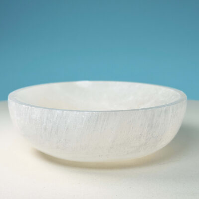 Selenit krystal 9,5 cm skål på hvid plade med blå baggrund