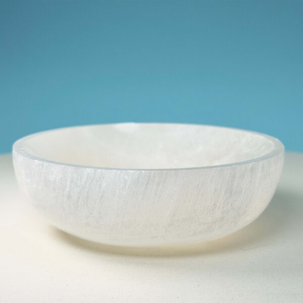 Selenit krystal 9,5 cm skål på hvid plade med blå baggrund