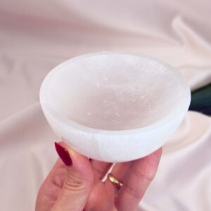 Selenit skål krystal sten 10 cm i hånd på hvid baggrund