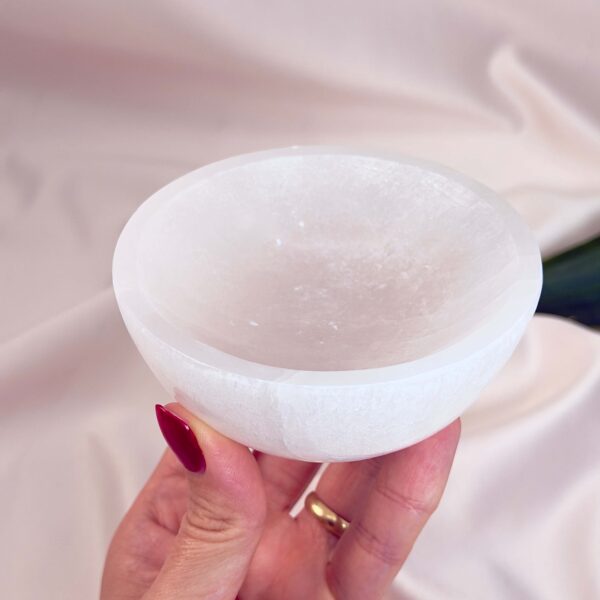 Selenit skål krystal sten 10 cm i hånd på hvid baggrund