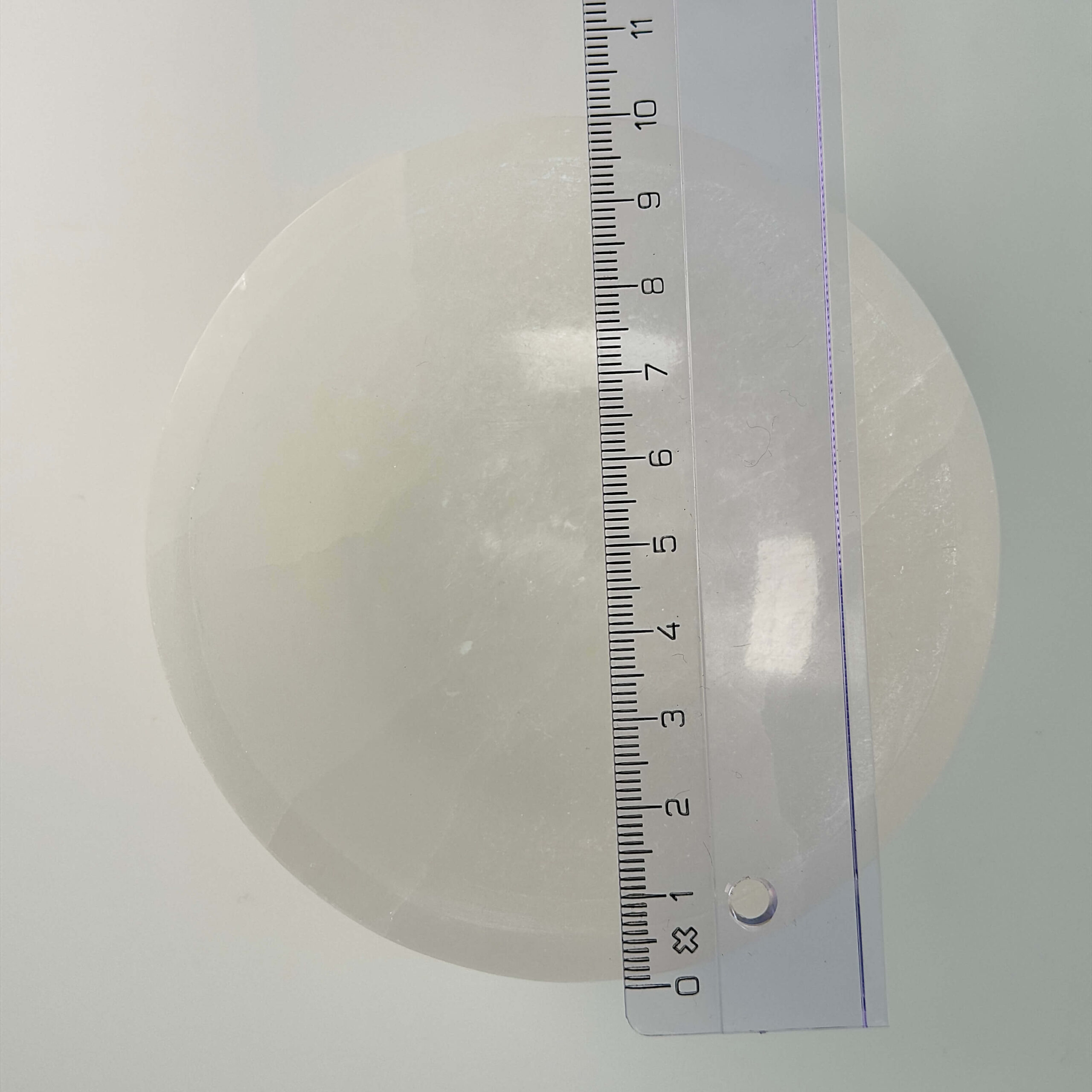 Selenit skål krystal sten 10 cm med lineal på hvid baggrund