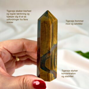 Tigerøje krystal tårn på hvid baggrund med grønt blad med tags