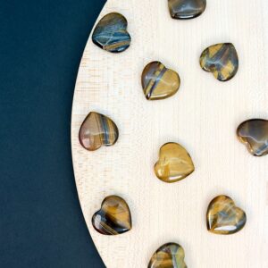 Tigerøje mini krystal hjerter på hvid plade med sort baggrund