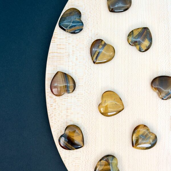 Tigerøje mini krystal hjerter på hvid plade med sort baggrund