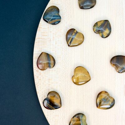 Tigerøje mini krystal hjerter på hvid plade med sort baggrund