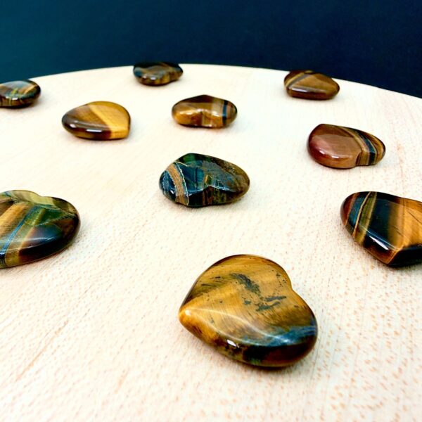 Tigerøje mini krystal hjerter på hvid plade med sort baggrund skrå