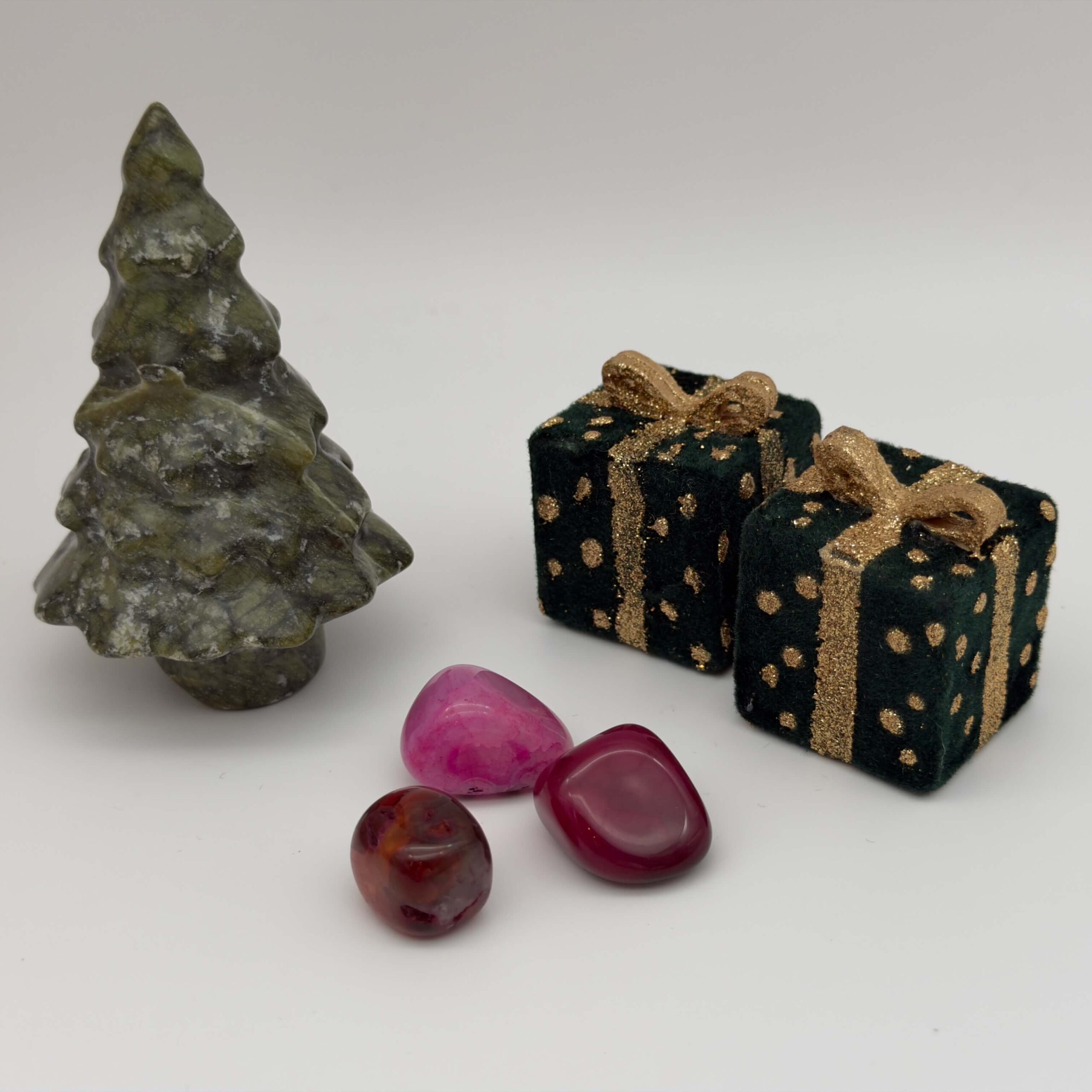 agat pink krystal ved juletræ og gaver på hvid baggrund