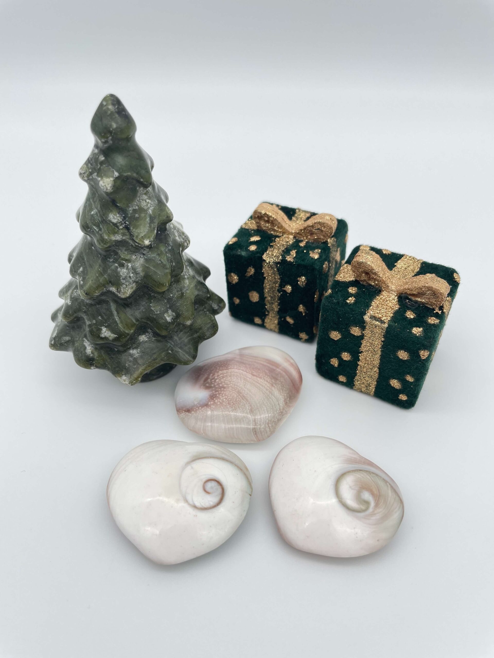 Shiva shell skal krystal ved juletræ og gaver på hvid baggrund