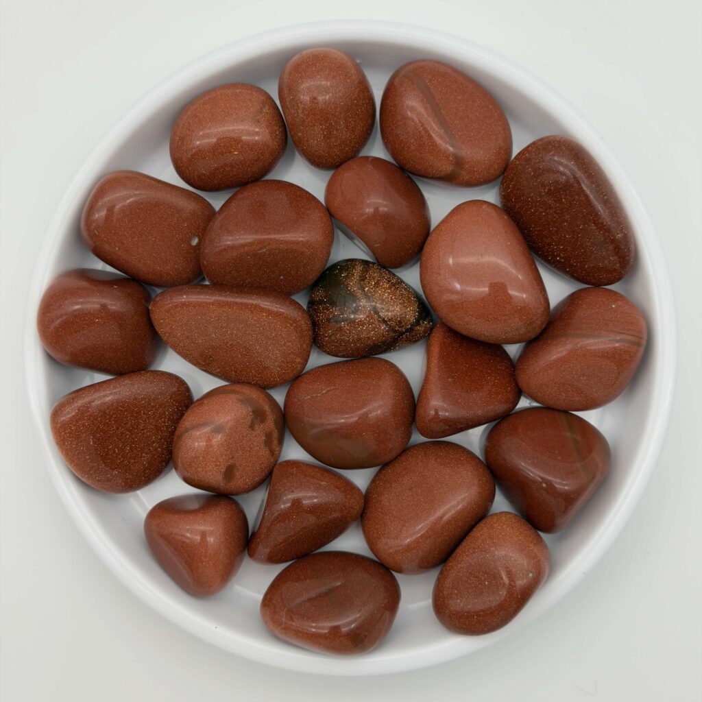 Guldsten krystal i hvidt fad med hvid bagggrund