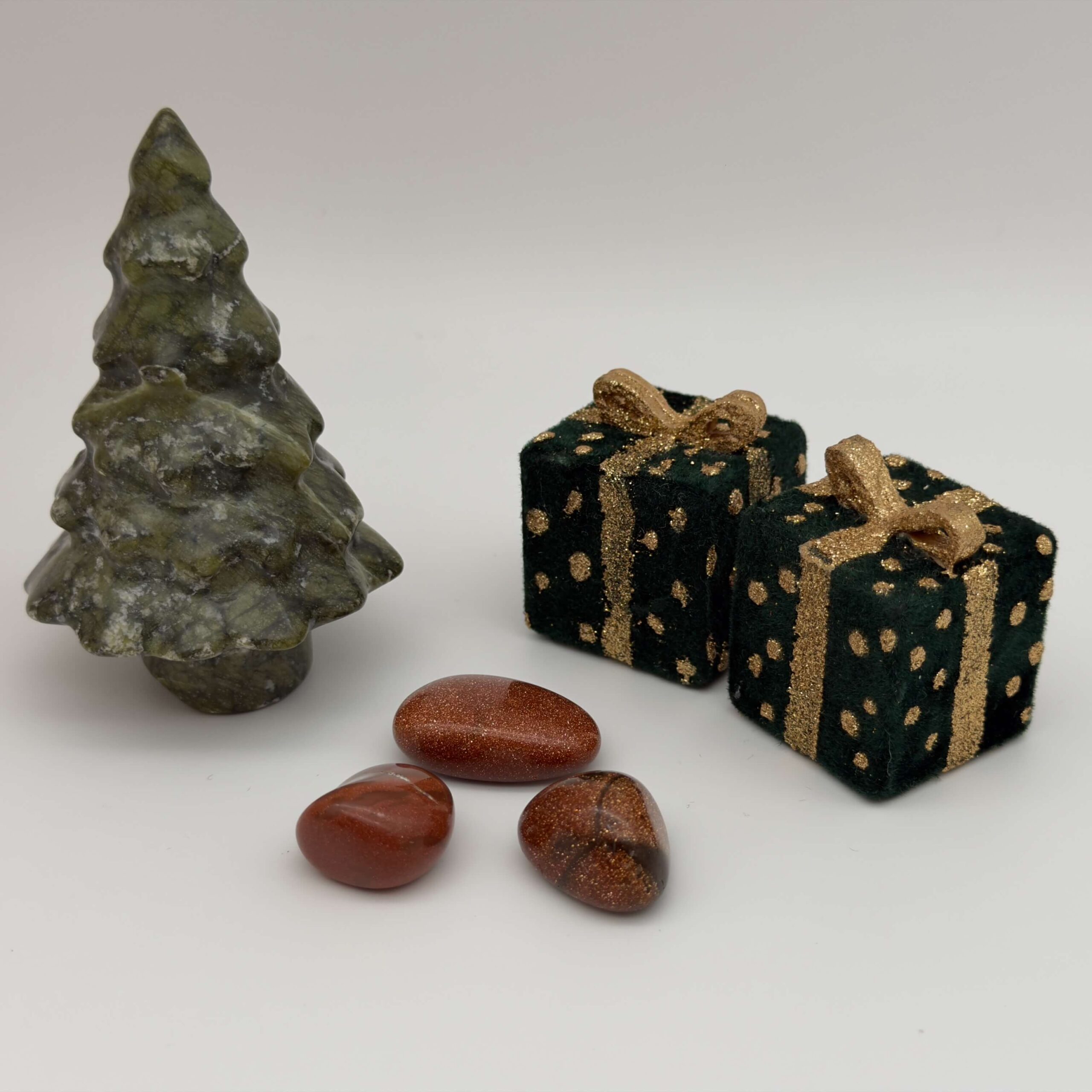 Guldsten krystal ved juletræ og gaver på hvid baggrund