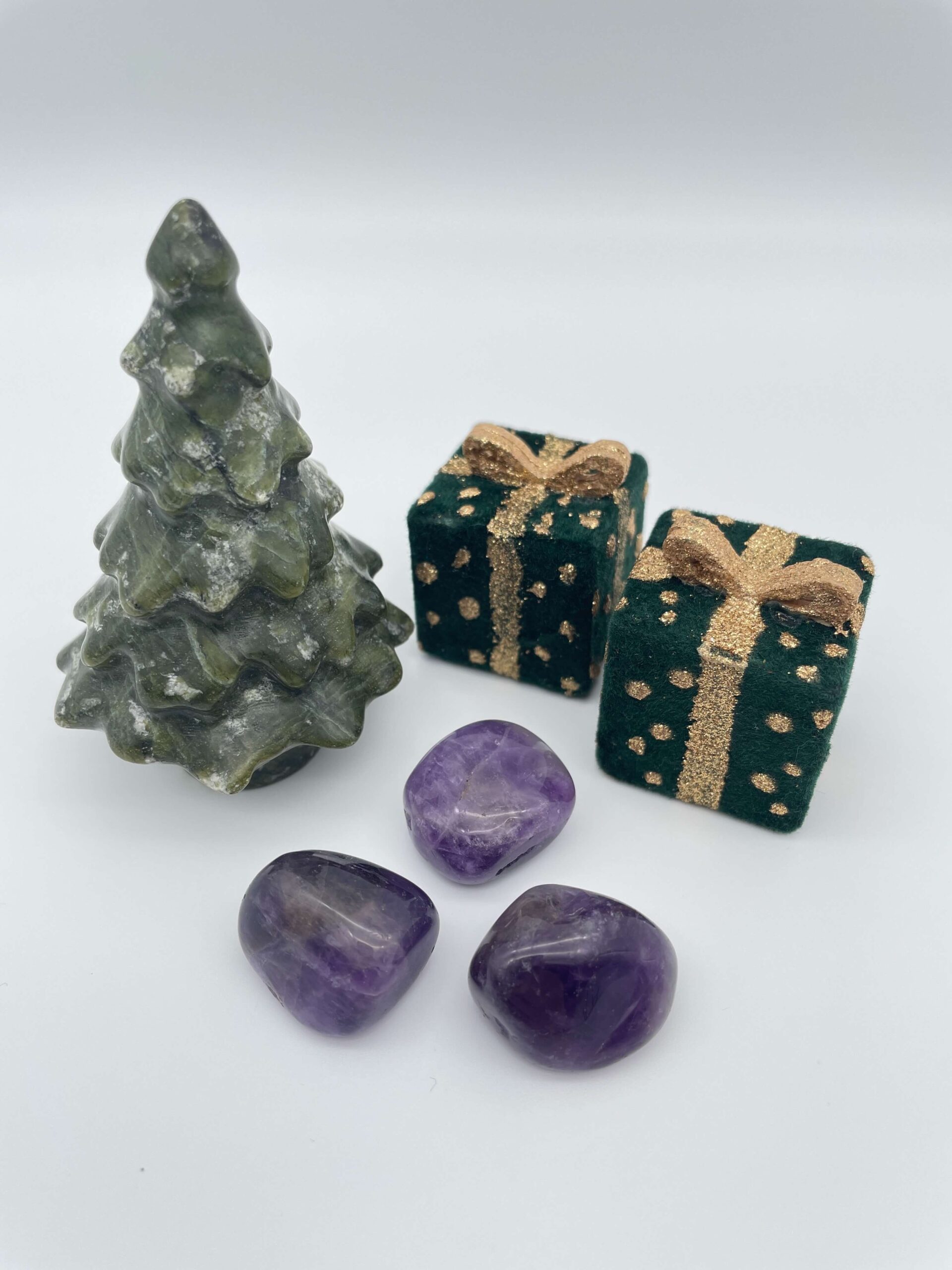 Ametyst mørk krystal ved juletræ og gaver på hvid baggrund