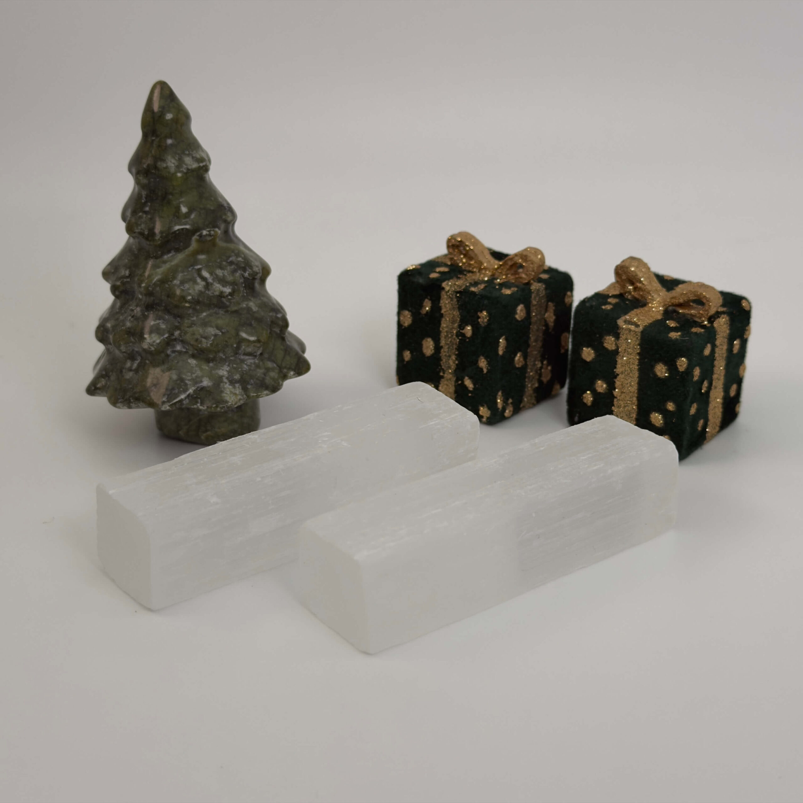 Selenit krystal ved juletræ og gaver på hvid baggrund