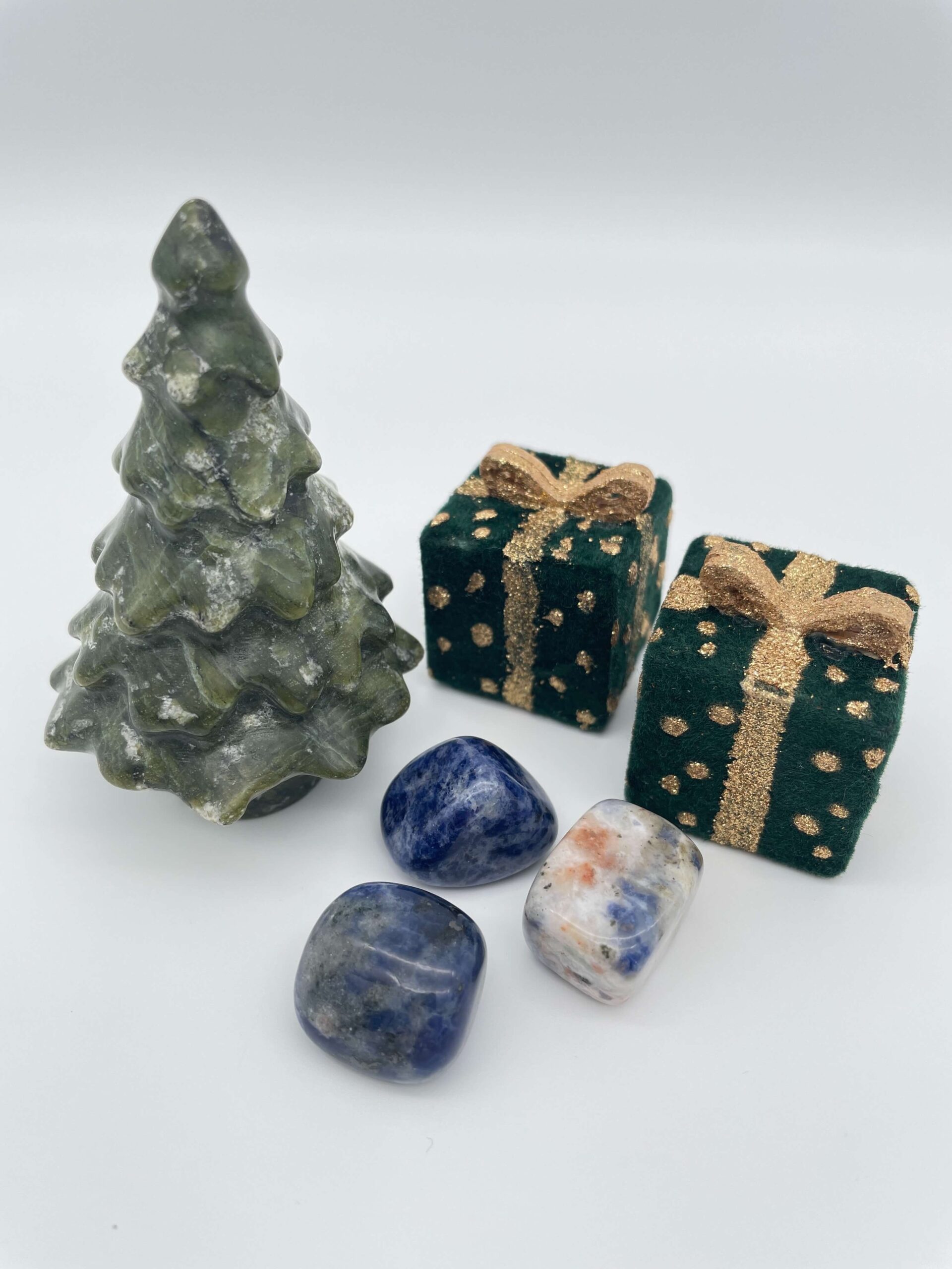 Sodalit krystal ved juletræ og gaver på hvid baggrund