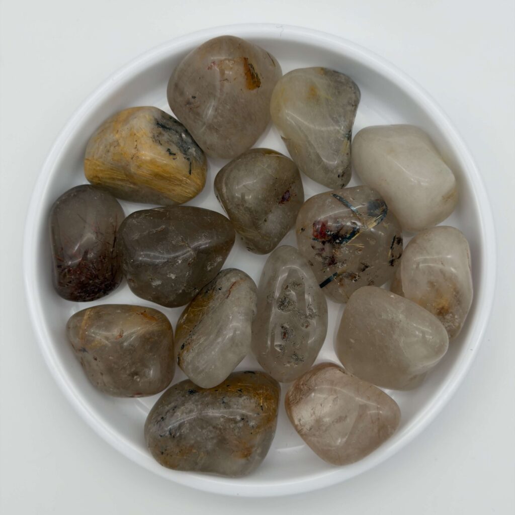 Rutilkvarts krystal i hvidt fad med hvid bagggrund