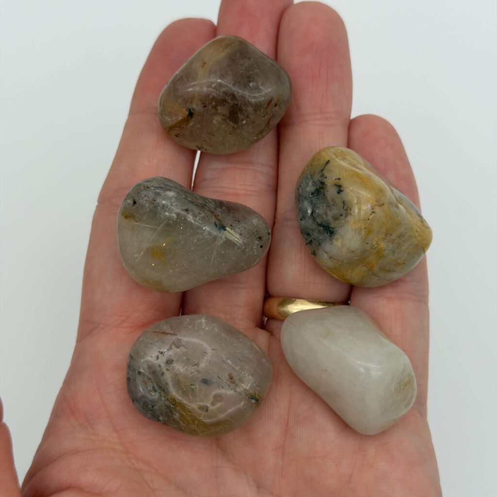 Rutilkvarts krystal i hånd med hvid baggrund