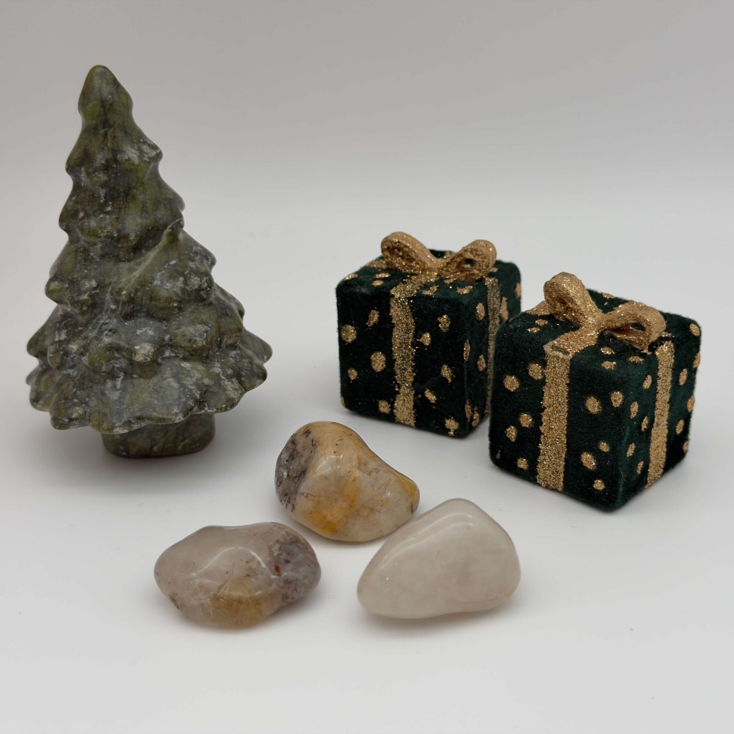 Rutilkvarts krystal ved juletræ og gaver på hvid baggrund