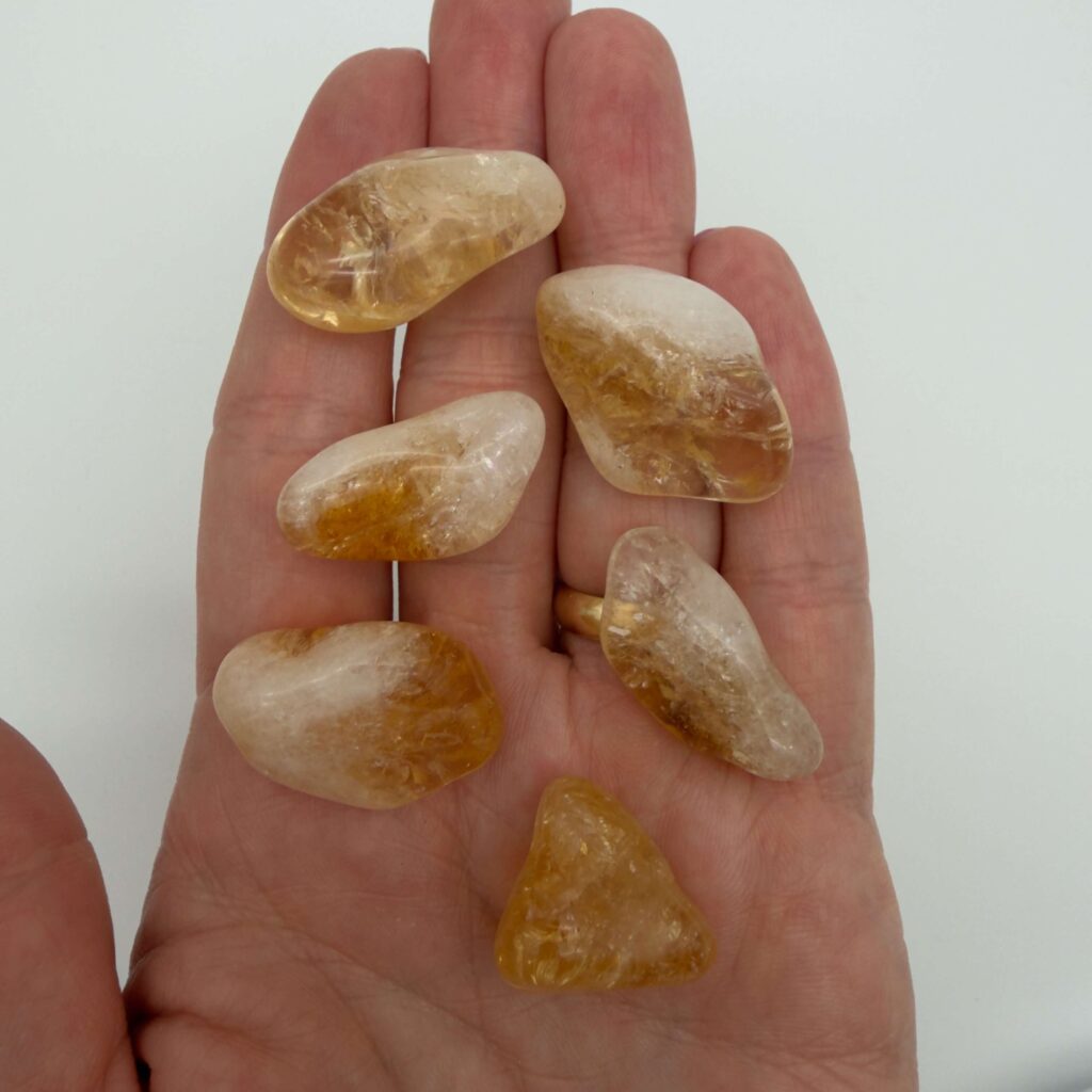 Glædelig 22. december – I dag finder du en Citrin i din julekalender 1 Brændt citrin krystal i hånd med hvid baggrund