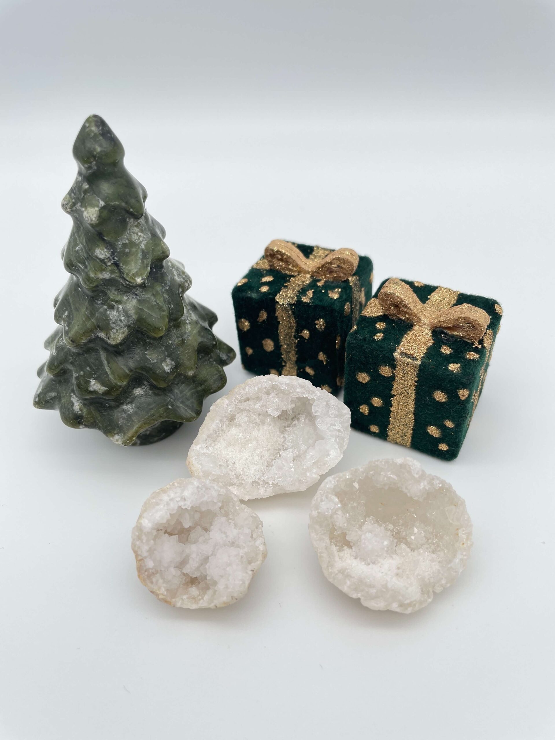 Bjergkrystal geode krystal ved juletræ og gaver på hvid baggrund