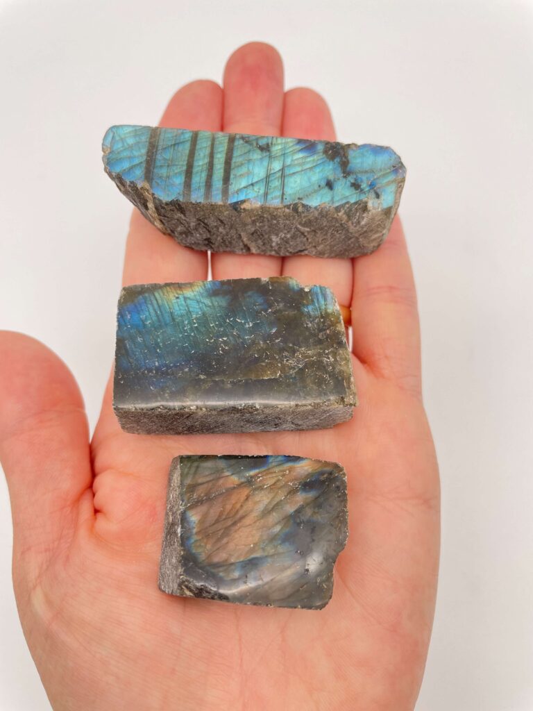 labradorit blok krystal i hånd med hvid baggrund