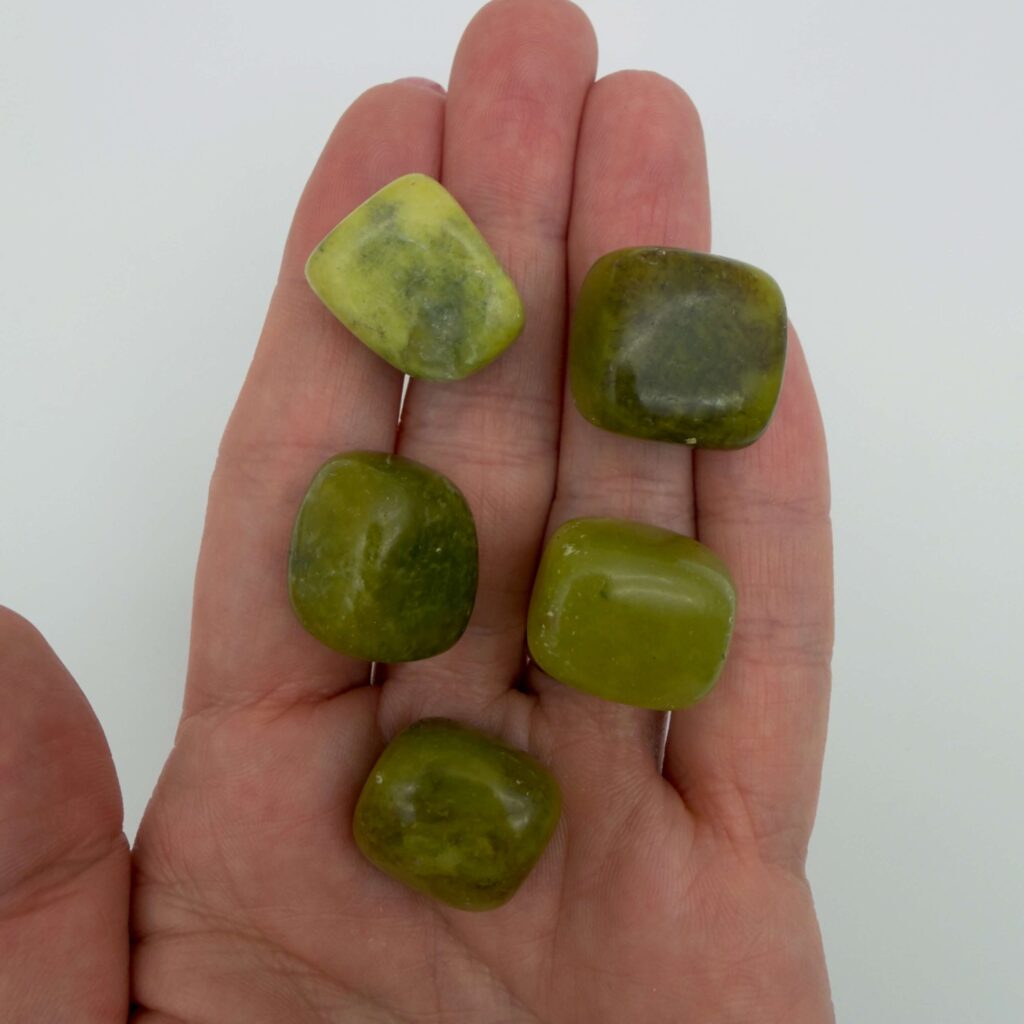 serpentin gul krystal i hånd med hvid baggrund