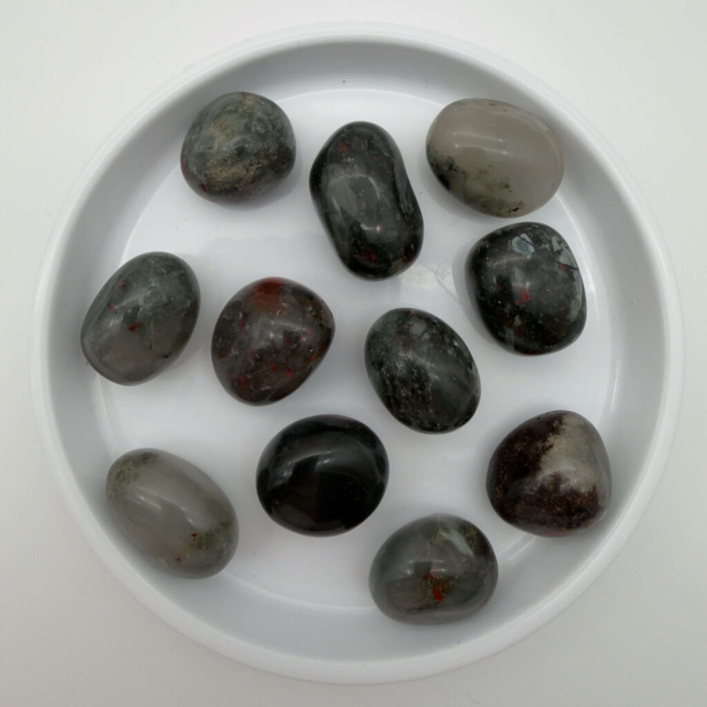 blodsten krystal i hvidt fad med hvid bagggrund